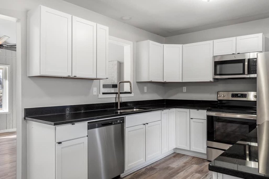 Remodeled kitchen with white cabinets and dark countertops in Kansas City, KS